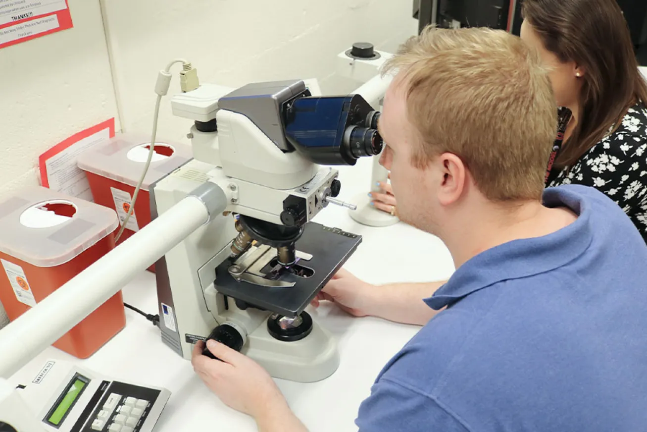 a man looking into a microscope
